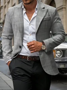 Stylish men's grey plaid blazer jacket with a peaked lapel in an urban setting.