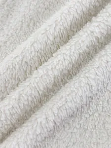 Close-up macro view of the soft white plush fleece fabric texture on a street jacket