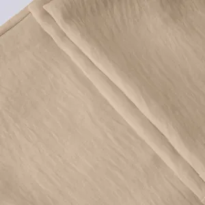 Close-up macro shot of beige breathable linen-like fabric texture for casual men's trousers