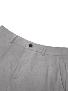 Detail view of grey business suit trousers waist with button and fabric texture details.
