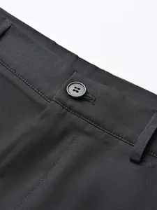 Close-up detail of black men's business suit trousers showing waist button and fabric texture