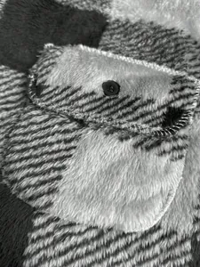 Detailed view of soft black and white checkered plush fabric and buttoned pocket