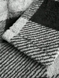 Detailed close-up showing the soft grey and black plaid plush texture of this winter jacket