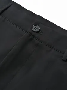 Close-up of black suit trousers featuring a button closure and fabric texture details.