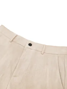 Close-up of beige formal suit trousers showing fabric texture, button, and belt loops.