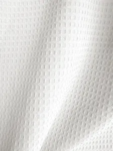 Detailopname van witte wafelstructuur stof voor een formeel heren kostuum jasje