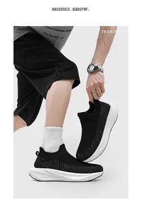 Side view of black fly-knit slip-on sneakers on a model with thick white soles