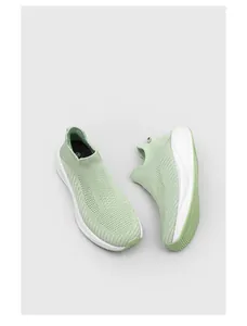 Top view detail of mint green breathable knitted slip-on sneakers with thick white soles