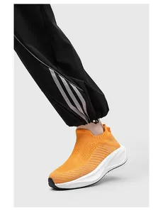 Close-up of orange knit sock sneakers featuring a breathable mesh and slip-on design
