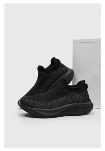 Close-up detail of breathable black knit sock sneakers with thick athletic cushioned soles