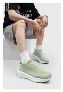 Close-up view of green breathable knitted mesh sock shoes with thick white soles on a model