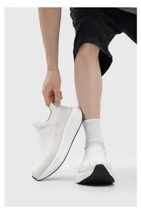 Close-up of white breathable flyknit slip-on sneakers with thick cushioned soles for men and women