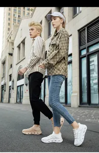 Primo piano di scarpe sportive in rete traspirante bianche e beige indossate all'aperto