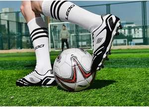 Actionaufnahme von Fußballschuhen auf Kunstrasenplatz mit Ball