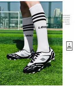 Professionelle Fußballschuhe in Weiß und Schwarz auf grünem Rasen mit weißen Socken