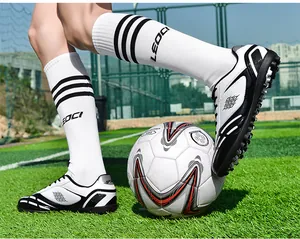 Action-Foto von TF-Nocken-Fußballschuhen für Kinder und Jugendliche auf Kunstrasenplätzen