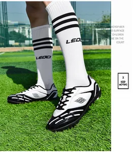 Kinder TF Fußballschuhe für Kunstrasen mit Mikrofaser-Oberfläche in Weiß und Schwarz.
