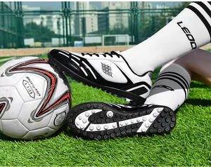 Professionelle schwarz-weiße Turf-Fußballschuhe für Kinder und Erwachsene auf Gras