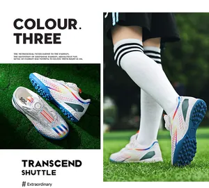 Children's soccer shoes with rotary buckle and rainbow TF studs detail on grass