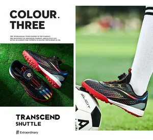 Detail view of kids soccer shoes with rotating buckle and rainbow stripes on turf.