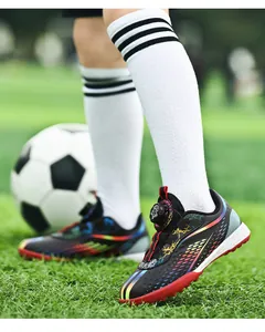 Professional children's soccer training shoes with rotary buckle on a green grass field