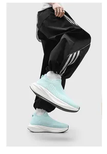 Professional side view of mint green breathable fly-knit slip-on sneakers for summer running.