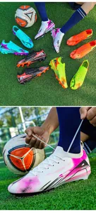 Close-up of vibrant low-top soccer cleats on grass with soccer ball