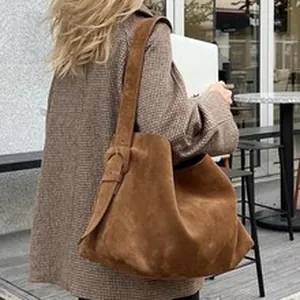 Large vintage brown suede hobo tote bag shown being worn over the shoulder for daily wear