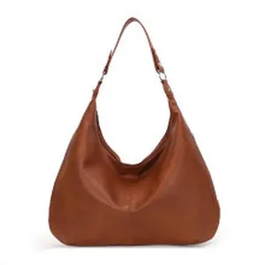 Frontal view of a minimalist brown faux suede hobo bag featuring a wide comfortable shoulder strap