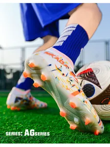 Close-up of professional soccer shoe sole with orange AG spikes on green grass.