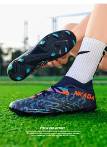 Detail of professional fly-knit soccer cleats with cleated soles on grass field