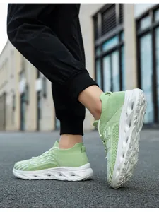 Dettaglio di sneaker a calzino in maglia verde chiaro traspiranti con suole ammortizzanti.