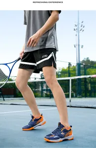 Gros plan détaillé des chaussures de sport bleu et orange sur un court de tennis