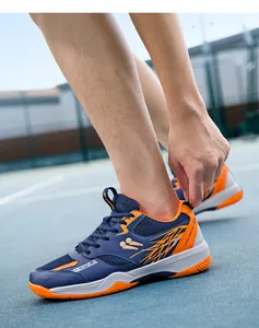 Détail de chaussures de sport respirantes en mesh bleu et orange sur un terrain