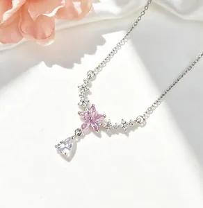 Vista dettagliata di una collana sakura in argento con petali rosa e cristallo a goccia.