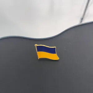 Macro-detail van de gegolfde Oekraïense vlag emaille speld met gouden metalen randen.