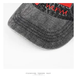 Nahaufnahme der roten WLFW-Stickerei auf dem Schirm einer verwaschenen Denim-Kappe