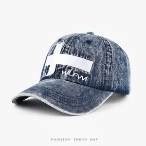 Washed denim baseball cap featuring an embroidered white cross for urban streetwear fashion