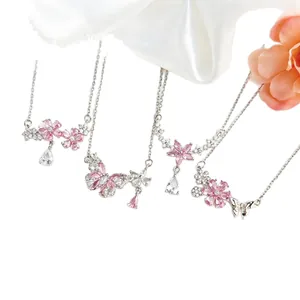 Eleganti collane con ciliegio rosa e farfalla su seta bianca.