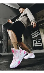 Macro view of stylish pink and white high-top basketball shoes worn by model in urban setting
