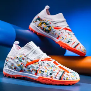 Detailed view of colorful turf soccer shoes with orange rubber studs and knit collar