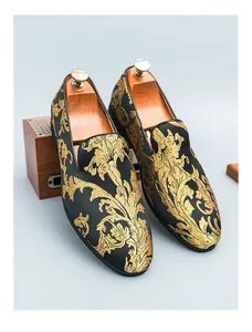 Nahaufnahme von schwarzen Herren-Loafers mit aufwendiger goldener Blumenstickerei