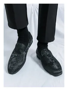 Detailaufnahme schwarzer Loafer mit Blumenmuster und eleganter Stickerei im China-Stil.