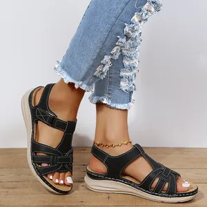 Close-up of black vintage cross-strap wedge sandals with white stitching detail
