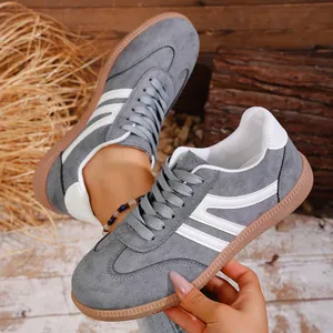 Retro grey suede sneakers with white stripes and gum rubber soles for casual wear