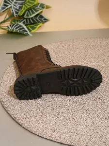 Vista detallada de la suela dentada y el perfil de una bota retro marrón para mujer