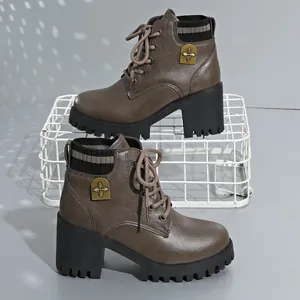 Detail view of brown chunky heel Martin boots with knitted collar and metal emblem.