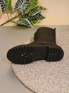 Detalle de la suela dentada antideslizante de una bota de media caña negra para mujer