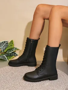Detalle de las botas negras de media caña para mujer con cremallera lateral