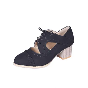 Gros plan sur des chaussures noires en PU à lacets vintage avec détails ajourés décoratifs